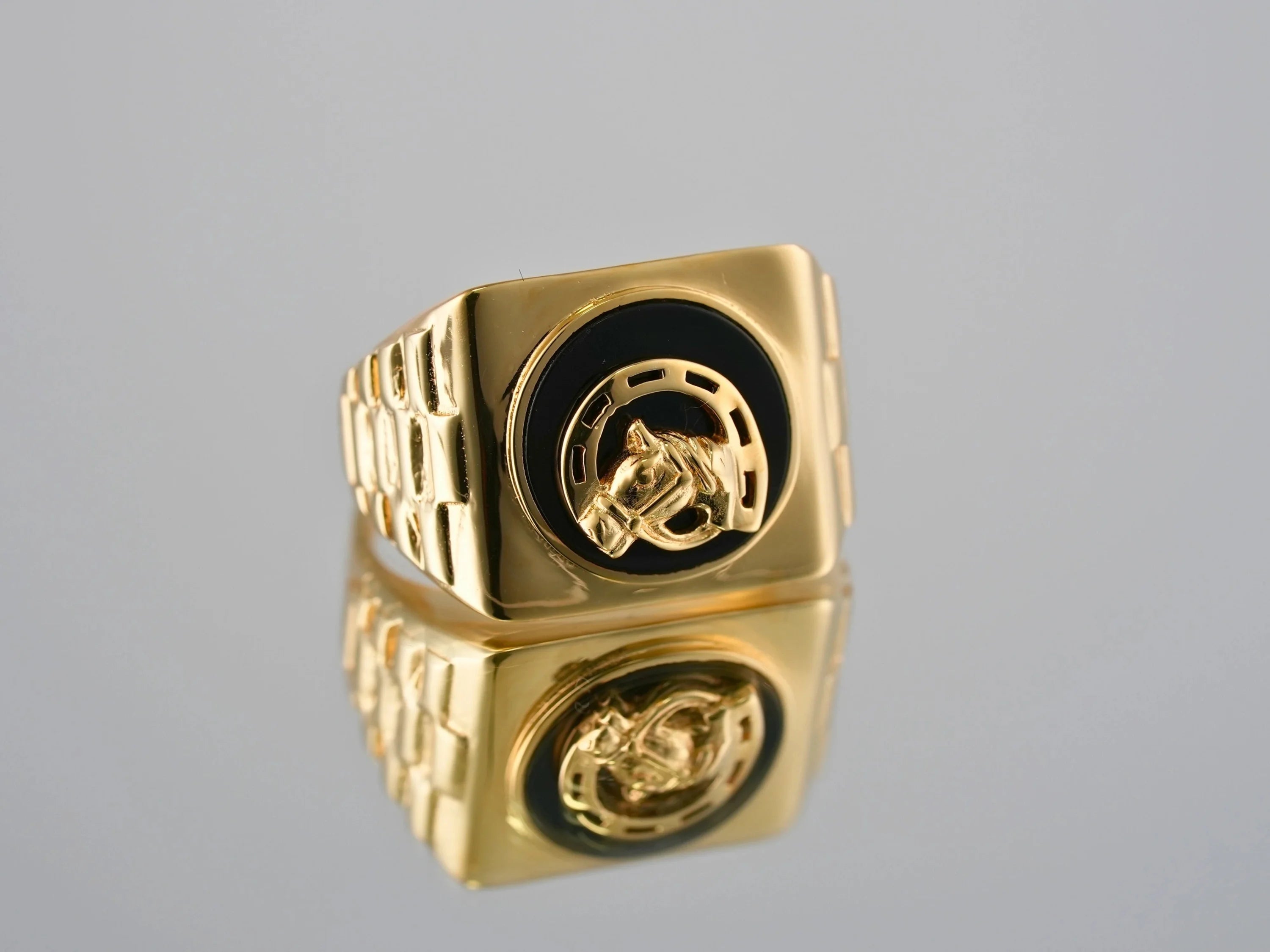 Gold ring with horse and horseshoe motif featuring 18kg Onix Horse Shoes design