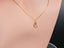 Mannequin displaying the 18 k gold cat pendant on a chain, illustrating the pendant's size and positioning on the neckline.