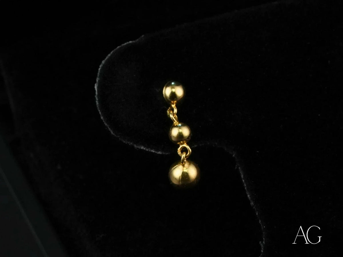Delicate 18k solid gold earrings with three descending spheres, elegant minimalist design