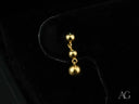 Delicate 18k solid gold earrings with three descending spheres, elegant minimalist design