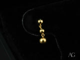 Delicate 18k solid gold earrings with three descending spheres, elegant minimalist design