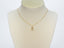 Mannequin bust wearing the 18 k gold cat pendant on a chain against a white background, showcasing the pendant’s size and proportion.