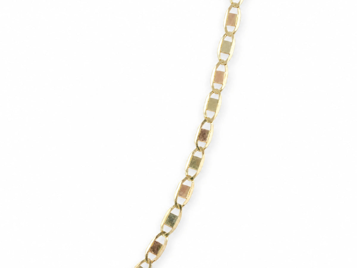 14K gold piastrine chain at a 45 degree angle, showing the length of the oval links and the plates inside them