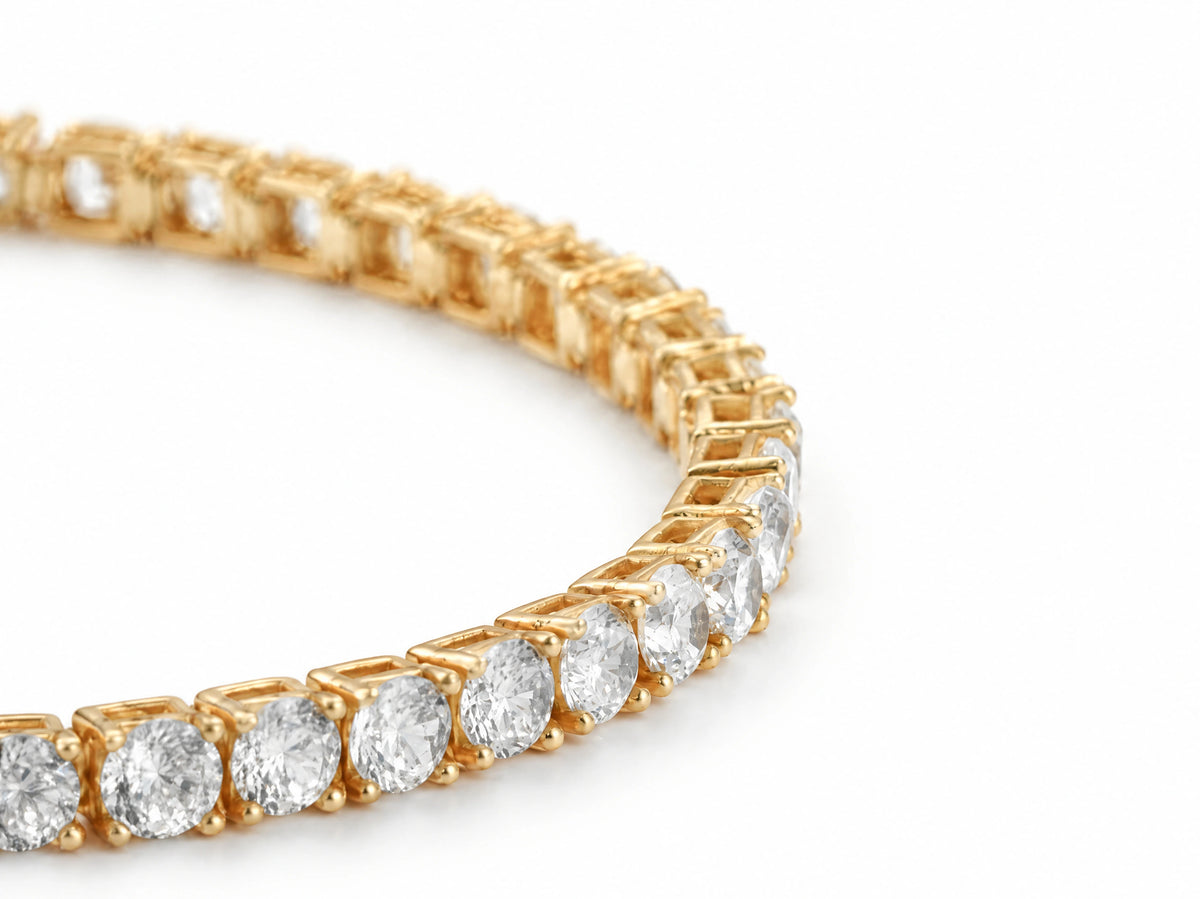 Three-quarter view along the bracelet where it curves across the white surface, the four-prong settings and the links between them in focus