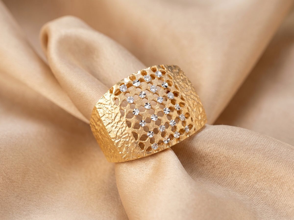 Malha 18K gold ring on champagne silk — two-tone yellow and white gold, diamond-cut band