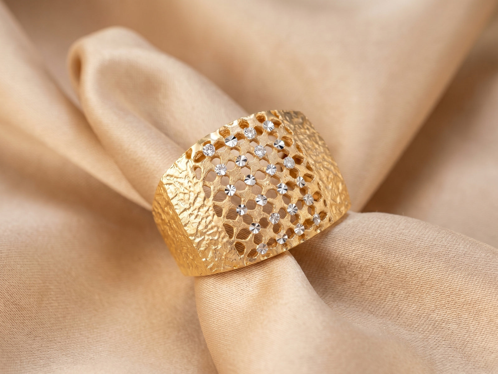 Malha 18K gold ring on champagne silk — two-tone yellow and white gold, diamond-cut band