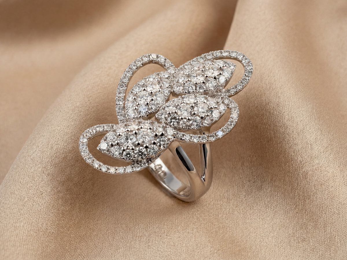 Angled view of 18K white gold diamond statement ring on champagne silk - ArtGold Jewelry