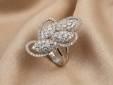 Angled view of 18K white gold diamond statement ring on champagne silk - ArtGold Jewelry