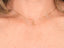Model wearing the 18 k gold cat pendant on a chain, demonstrating how the charm looks on the neckline.