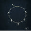 18k gold charms anklet with five cross charms on dark background.