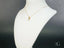 Gold necklace with Azure Spark Blue Topaz pendant displayed on white jewelry bust