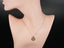 Model wearing solid 18 K gold Celestia initial disc necklace at collarbone—minimalist red-carpet style like Taylor Swift.