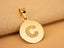 Close-up of 15 mm Celestia disc pendant on beige fabric, brushed engraving and polished edges; red-carpet glam akin to Taylor Swift.