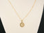 Celestia disc pendant on beige display bust, showing pendant size and drape; red-carpet style in the vein of Taylor Swift necklaces.