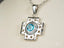 Silver Cross Pendant with Blue Topaz and Diamonds in 18k White Gold