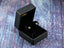 Star-shaped stud earrings in a black jewelry box, featuring dazzling 18k yellow gold