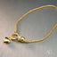 Delicate Charm 18k gold bracelet with heart and ring adorned with zirconia stones, symbolizing love and elegance.