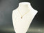 Delicate 18k Gold Dual Elegance Pendant with red gemstone on white jewelry bust