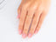 Delicate 18k yellow gold ring with cubic zirconia on pink manicured nails