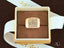 Elegant 18k yellow gold ring with a lattice pattern in a luxurious jewelry box