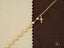 Elegant 18k gold necklace with pearl-like beads and cross motif pendant