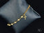 Elegant women’s 18k gold bracelet featuring cross motif and polished gold beads
