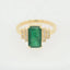 18k gold ring featuring a 2.3ct emerald with diamond halo.