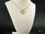 Gold double heart pendant with filigree design on an 18k gold chain necklace