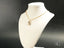 Gold chain necklace with Golden Bloom floral design pendant on white jewelry bust