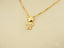 18k gold Golden Charm Doll Pendant featuring a stylized figure charm with crystals