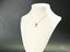 18k Gold Golden Charm Doll Pendant on white jewelry bust for stylish display