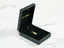 Black jewelry box with 18k gold ring and Golden Charm Doll Pendant displayed