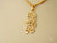 Gold pendant necklace featuring stick figure boy in hat from Golden Cherish collection