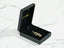 Black jewelry box showcasing the Golden Cherish Pendant with a gold-colored brooch