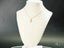 Gold necklace with a star pendant on a bust, featuring an 18k gold charm