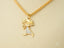 Gold Doll Pendant featuring a stick figure charm in 18k gold with textured dress pattern