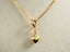 18k gold golden heart pendant elegantly hanging from a delicate chain necklace