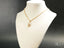 Gold-toned 18k gold necklace with cubic zirconia padlock pendant on white bust