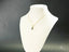 18k Gold Golden Love Pendant necklace on a white jewelry bust display
