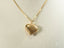 Gold heart-shaped pendant necklace with a textured mesh pattern in 18k gold design