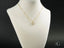 Gold heart pendant necklace in 18k gold with cubic zirconia on white bust display