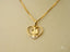 Gold heart-shaped pendant necklace with cartoon character and crystal accent in 18k gold