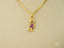 Gold pendant necklace featuring a girl figure in a purple dress from Golden Ruby Doll