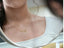 Golden Signature Necklace in 14k gold with custom name plate, worn by a woman.