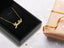 Golden Signature Necklace in 18k or 14k gold with customizable name plate displayed in an elegant jewelry box.
