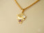 18k Gold Golden Son Pendant showcasing a stylized girl figure wearing a hat