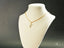 18k Gold chain necklace featuring a Golden Treasure Pendant on a white jewelry bust