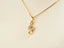 Gold-toned treble clef pendant necklace with rhinestones from Harmonic Elegance collection