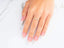 Delicate 18k yellow gold ring with small diamonds worn elegantly on a finger