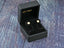 Gold stud earrings in a black jewelry box showcasing Luxe Brilliance 18K Yellow Gold Pave design